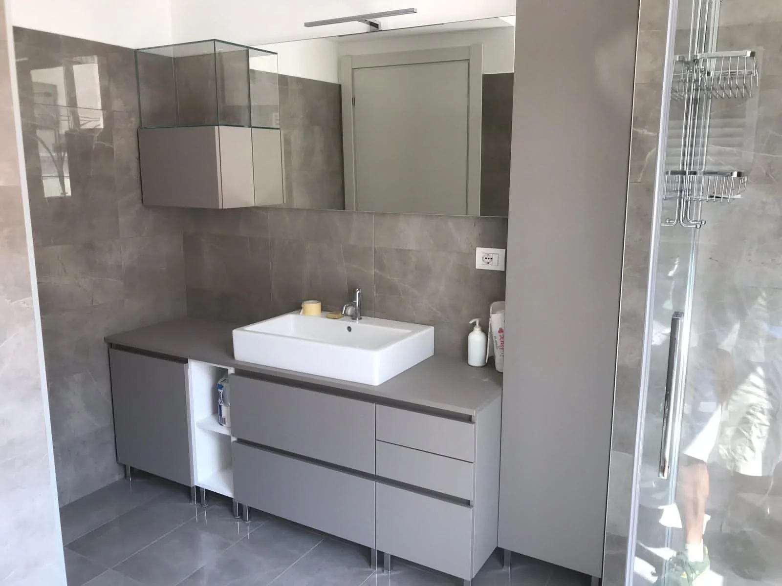 Arredo bagno a disegno con piedini alti e lavabo in appoggio